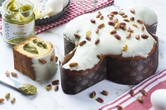 Colomba di pasticceria ricoperta di cioccolato bianco e pistacchi con vasetto di crema al pistacchio